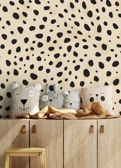 three stuffed animals sitting on top of a wooden cabinet in front of a leopard print wall