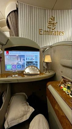 the inside of an airplane with a bed, desk and computer monitor on it's side