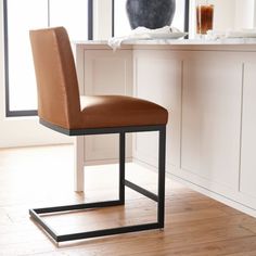 a brown chair sitting on top of a hard wood floor next to a countertop