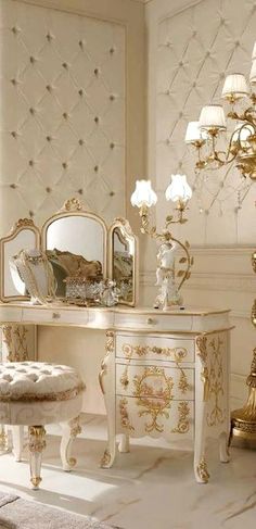 an ornate white dressing table with mirror and stool