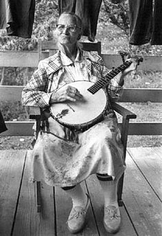 an old man sitting in a chair holding a guitar