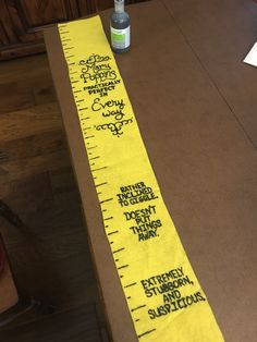 a measuring tape with writing on it sitting on a table next to a bottle of water