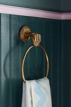 a gold towel ring on the wall in a bathroom