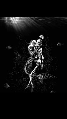 two skeletons are in the water with fish around them