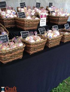 baskets filled with different types of candies on top of a black tablecloth covered table