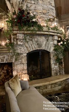 a living room with a stone fireplace and lots of candles