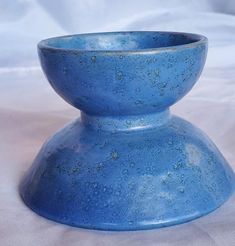 a blue vase sitting on top of a white sheet