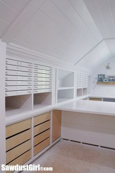 a white kitchen with lots of cabinets and drawers on the counter top in an attic