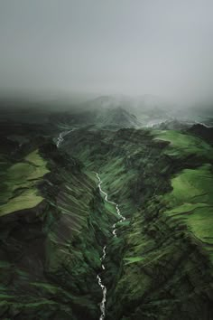 an aerial view of a river running through green hills