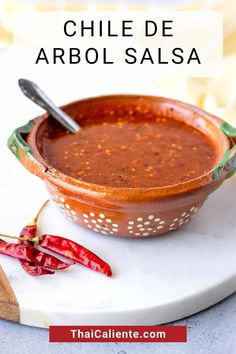 a bowl of chili sauce on a plate with the words chile de arbol salsa