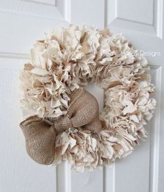 a burlap wreath hanging on a white door