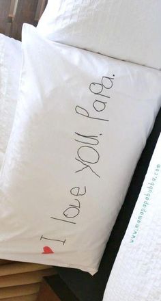 two white pillows with writing on them sitting next to each other