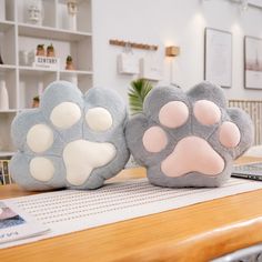 two stuffed animals sitting on top of a wooden table