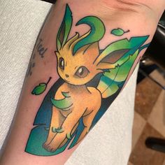 a person with a tattoo on their arm has a yellow and green pikachu