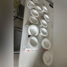 white plates and bowls are arranged on the wall