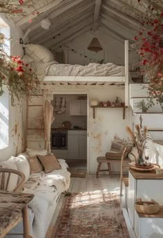 an old - fashioned bedroom is decorated in white and wood with red flowers hanging from the ceiling