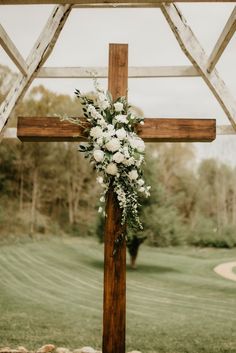 a cross decorated with flowers and greenery