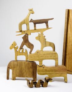 wooden toy animals sitting next to each other in front of a white background with an easel