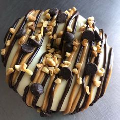 a chocolate covered donut with white frosting and nuts