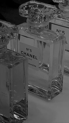 chanel perfume bottles are lined up on the table in this black and white photo