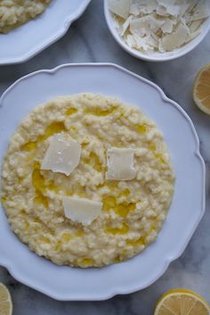 there are two plates with oatmeal and lemons on the table next to them