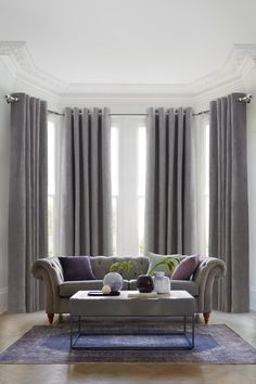 a living room filled with furniture and curtains