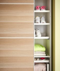 an open closet with shoes and clothes on shelves