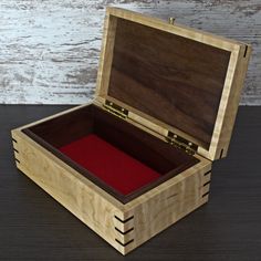 an open wooden box with red velvet inside