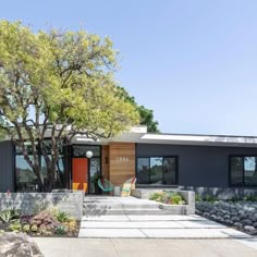 a modern house with an orange front door