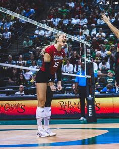 two women playing volleyball in front of an audience