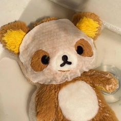 a brown and white teddy bear sitting on top of a sink