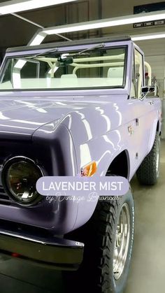 a purple truck parked in a garage next to another vehicle with the word lavender mist on it