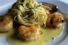 a white plate topped with pasta and shrimp