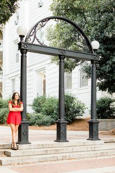 a woman in a red dress is standing on some steps