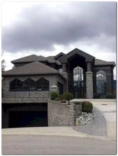 a large house with a car parked in front of it and two garages on the other side