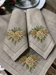 three napkins with pine cones on them