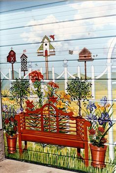 a painted mural on the side of a building depicting a bench with flowers in it