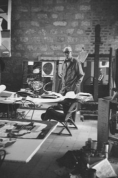 a black and white photo of a man in an art studio