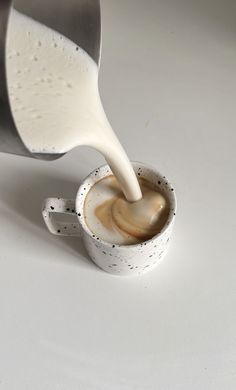 a cup filled with liquid being poured into it