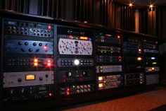 an array of sound mixing equipment in a room with lights on the wall and floor