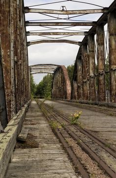 an old rusty bridge with train tracks going over it