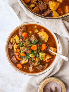 two bowls of beef stew with carrots and potatoes