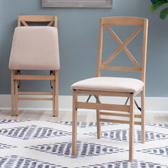 two wooden chairs sitting next to each other on a rug