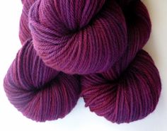 two skeins of purple yarn on a white surface