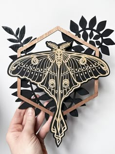 Home and Event Decor: Wall Hangings | Calendars | Garlands | Ouija Boards | Moon and Celestial | Functional Art | Coasters | Ornaments | Cake Toppers | Event Accessories  Home Decor Collection Our layered wall art brings nature and geometric shapes together by highlighting the intricacy of both elements. Here we have the Luna Moth adorned with ferns and a rose gold hexagon, which helps frame the the natural aspects of each. PRODUCT DETAILS -Approximately 9" x 9" -Crafted from 3 layers of birch wood -3/8th inch thick -Stained black and painted rose gold -Detailed engraving on the front of the moth only -Wooden hook on back for easy hanging Take a look at the FAQ section for more product information, and the shop announcement will have an up to date production lead time. All items are create Hanging Calendar, The Moth, Laser Engraved Ideas, Etsy Inspiration, Laser Art, Luna Moth, Insect Art, Art Party, Crafty Diy