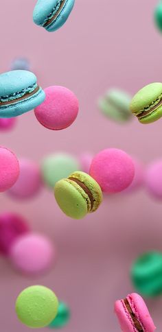 colorful macaroons flying in the air on pink background