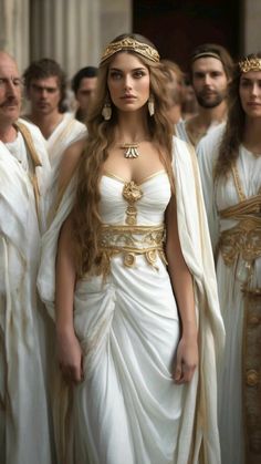 .   Woman in white peplos and gold jewelry standing in front of a group of people, Greek beautiful woman, delicate face, graceful figure, luxury of golden long hair, elegant ancient Greek peplos, dressed in ancient Greek clothes, bracelets, ornament on the walls White And Gold Gown Goddesses, Greek Gods Cosplay, Goddess Ball Gown, Greek Goddess Dress Gowns, White Greek Goddess Dress, Greek God And Goddess Costume, Greek Peplos, Greek Godesses Costume, Greek Dress Goddesses