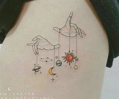 the back of a woman's stomach with an image of two hands and planets hanging from strings