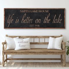 a wooden bench sitting in front of a black and white sign that says, smith lake house life is better on the lake