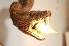 a close up of a lamp with a snake on it's head and mouth